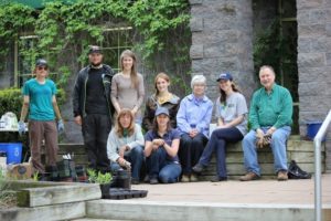 A group of people posing near a garden