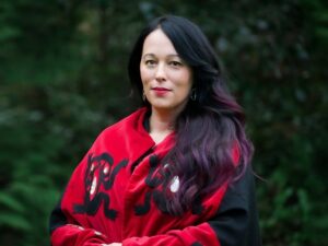 Photo of Dr. Jennifer Grenz wearing red, with her hair pulled over her shoulder. 